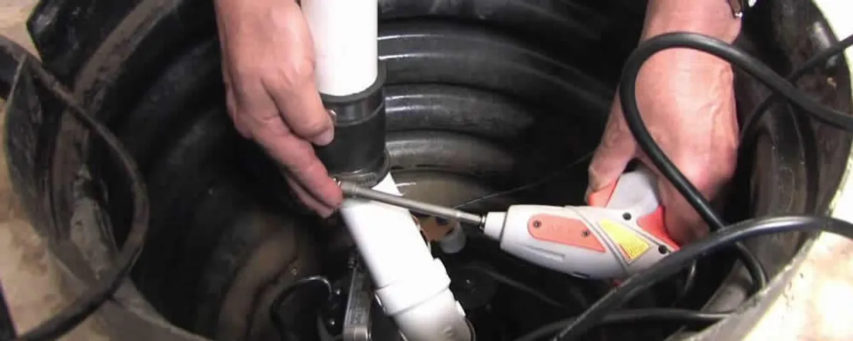 Sump pump installation technician connecting PVC discharge piping in Allentown, PA